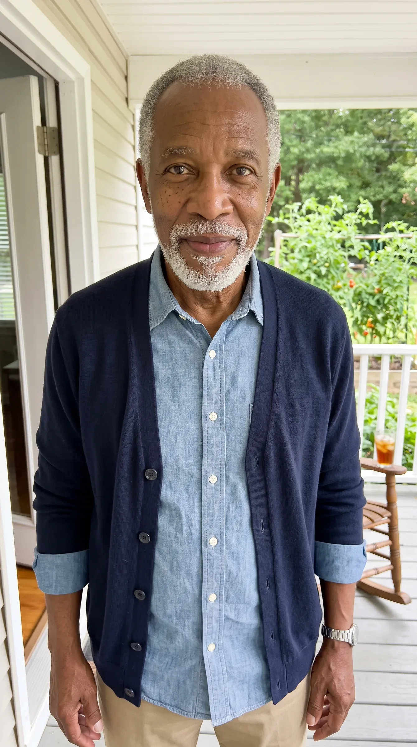 AI-generated grandfather with a white beard and navy cardigan on a back porch